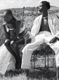Black and white fashion editorial photograph of Adut Akech and Bior Akech posing outdoors in grassy landscape for Vogue Australia.