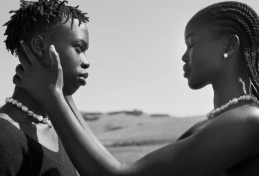 Black and white portrait of Adut Akech and Bior Akech facing each other in the project Two Of Us for Vogue Australia.
