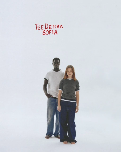 A man and a woman pose in front of a white background with red typography above them. The models wear casual clothing and stand barefoot.